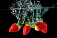 Erdbeeren fallen ins Wasser