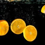 Orangenscheiben fallen ins Wasser schöne Luftblasen