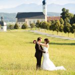 Hochzeitsfoto-10, Paar in der Wiese im Hintergrund Kirche und Berge