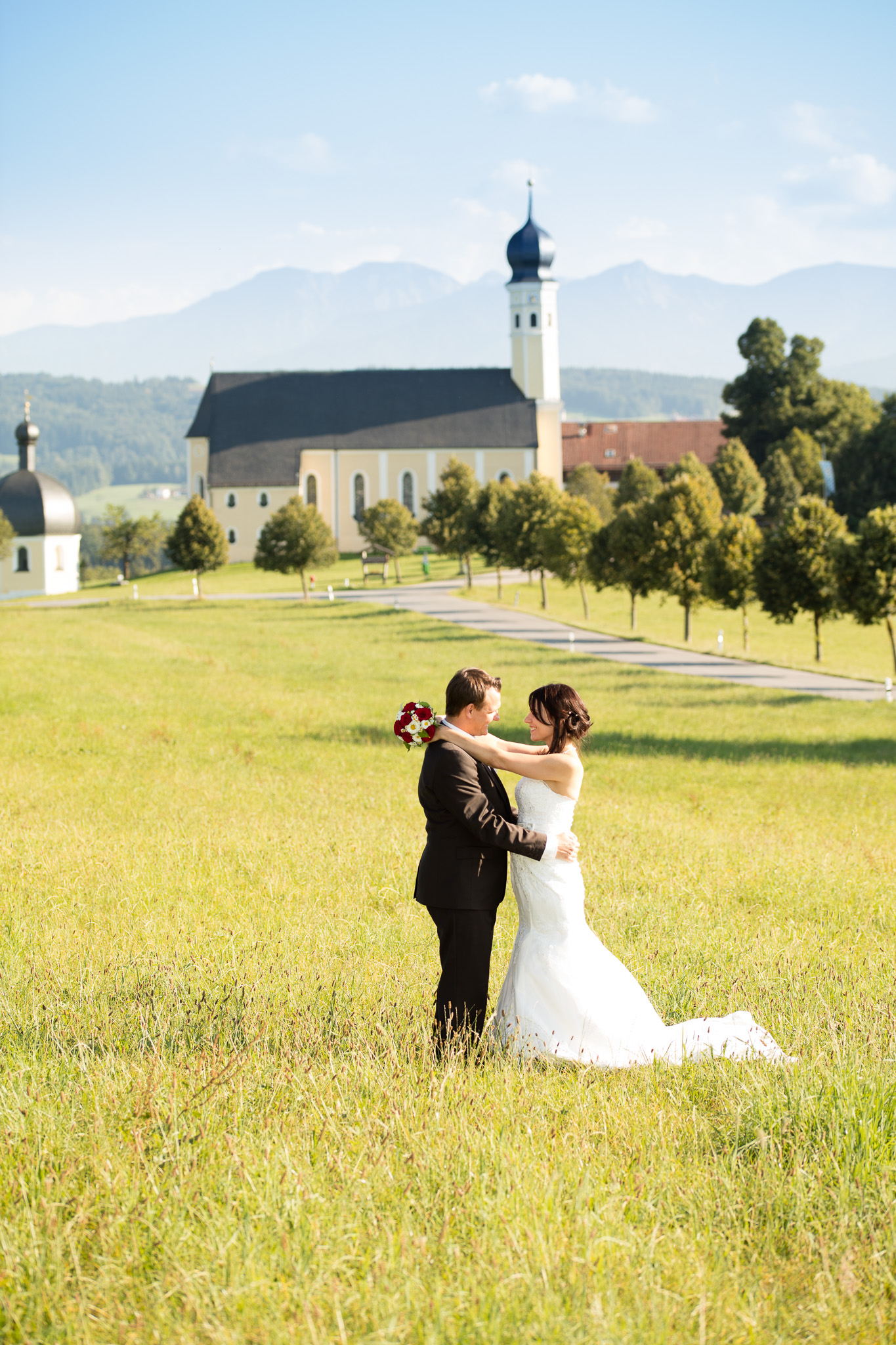 Hochzeitsfoto-10, Paar in der Wiese im Hintergrund Kirche und Berge